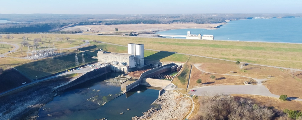 Aerial view of Lake Texoma Dam showing spillway, power station, and open water along the Texas–Oklahoma border