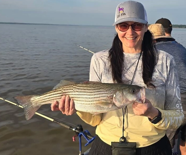 Woman holding striped bass Lake Texoma fishing trip