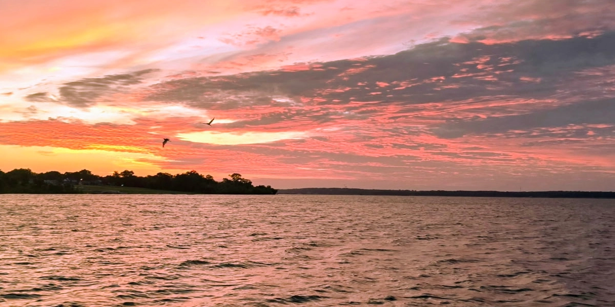 Sunrise over Lake Texoma showing changing weather and water conditions for striped bass fishing